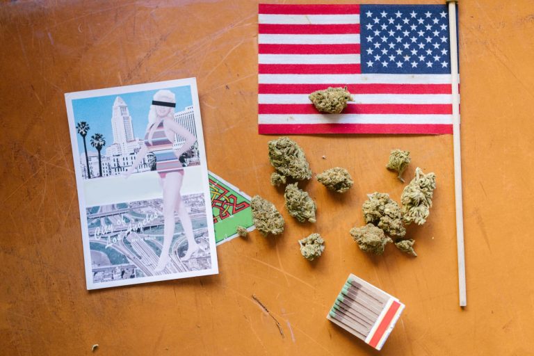 A collage of American culture with cannabis buds, matchsticks, and Los Angeles imagery on a wooden surface.